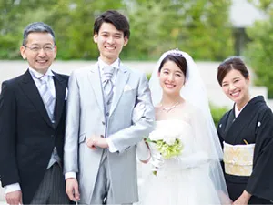 結婚式で新郎新婦と写真撮影する親御様